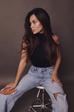 Stüdyoda poz veren siyah saçlı güzel bir kadının moda fotoğrafı.