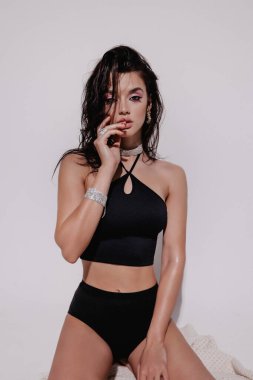 Stüdyoda poz veren siyah saçlı güzel bir kadının moda fotoğrafı.