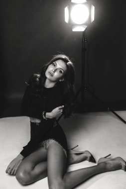 Stüdyoda poz veren siyah saçlı güzel bir kadının moda fotoğrafı.