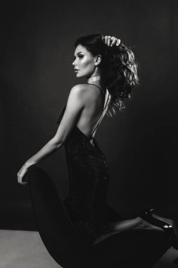 Stüdyoda poz veren siyah saçlı güzel bir kadının moda fotoğrafı.