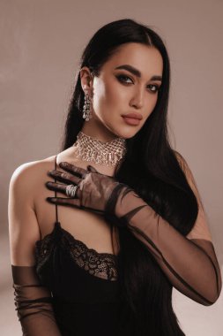 Stüdyoda poz veren siyah saçlı güzel bir kadının moda fotoğrafı.