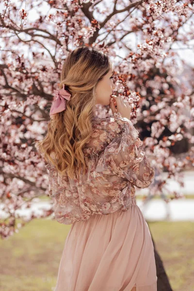 春花公园里 一位金发碧眼 穿着雅致衣服的漂亮女子摆姿势 与木兰花合影的户外时尚照片 — 图库照片