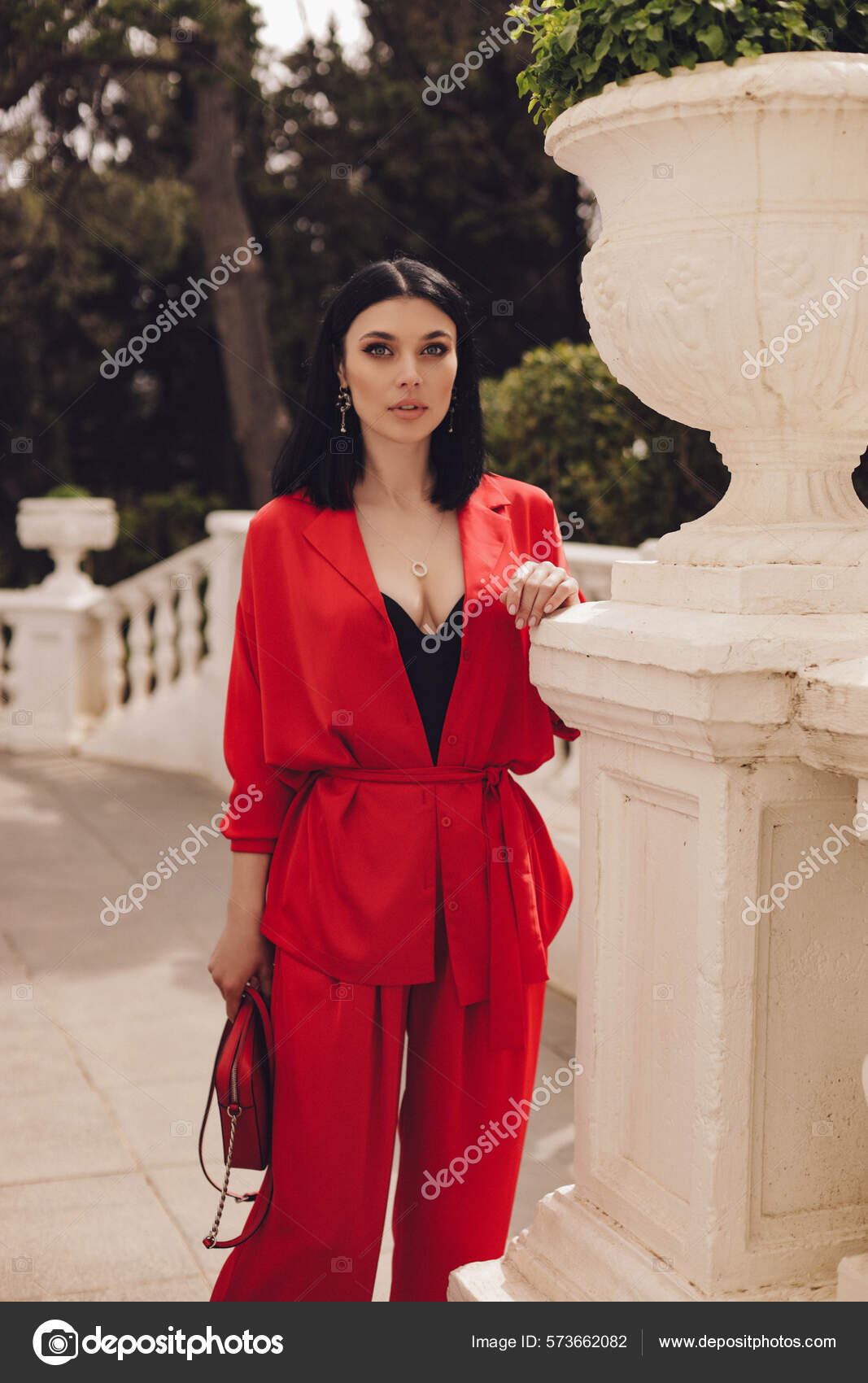 Fashion Outdoor Photo Of Beautiful Sexy Woman With Dark Hair In Elegant Red  Suit With Accessories Walking By The Street Stock Photo, Picture and  Royalty Free Image. Image 119892401.