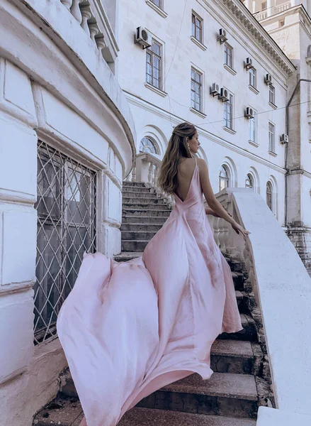 美しい女性のファッション屋外写真ブロンドの髪で豪華な絹のドレスが意味ある場所にポーズ — ストック写真