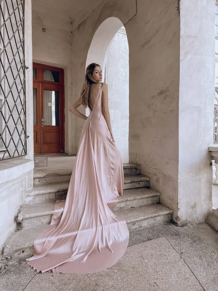 美しい女性のファッション屋外写真ブロンドの髪で豪華な絹のドレスが意味ある場所にポーズ — ストック写真