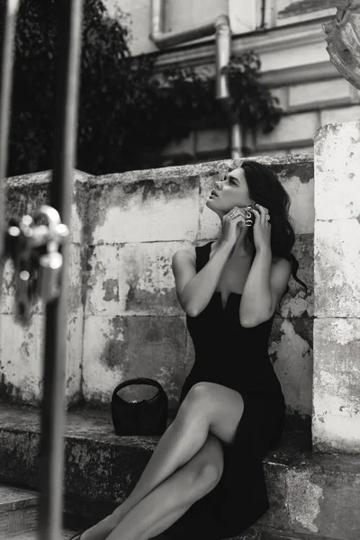 城市街道上穿着雅致的黑色连衣裙 头戴黑发的漂亮女人的户外时尚照片 — 图库照片