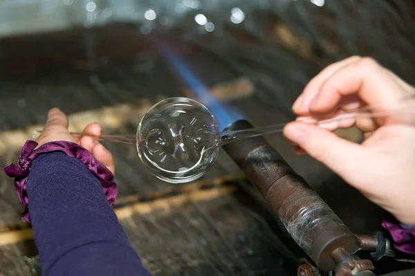 Glassblower heats the glass piece — Stock Photo, Image