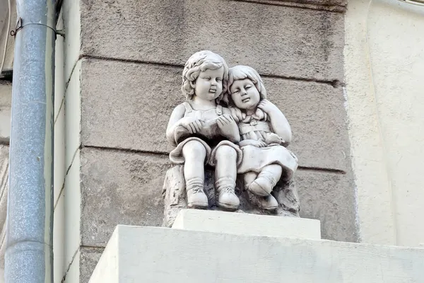 Due Sculture Bambini Sulla Facciata Della Vecchia Casa All Aperto — Foto Stock