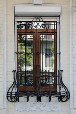 Iron lattice on window with white bas relief beneath in Kyiv Ukraine