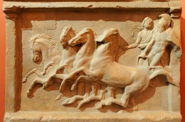 Savaş arabasındaki erkekleri tasvir eden Yunan tarihi harap olmuş taş tasfiyesi