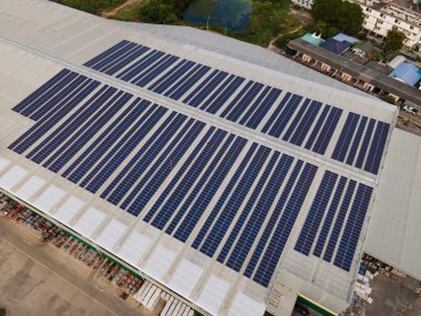 Büyük bir endüstriyel binanın çatısına ya da bir depoya kurulmuş güneş panellerinin insansız hava aracı görüntüleri. Sanayi binaları. Yenilenebilir enerji kaynakları. Yeşil güç fotovoltaik..