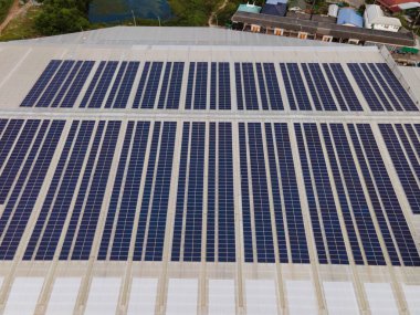 Büyük bir endüstriyel binanın çatısına ya da bir depoya kurulmuş güneş panellerinin insansız hava aracı görüntüleri. Sanayi binaları. Yenilenebilir enerji kaynakları. Yeşil güç fotovoltaik..