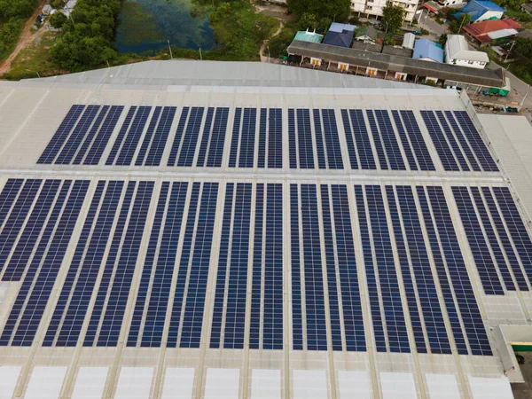 Aerial drone image of solar panels installed on a roof of a large industrial building or a warehouse. Industrial buildings.The renevable energy sustainable sources green power photovoltaic.