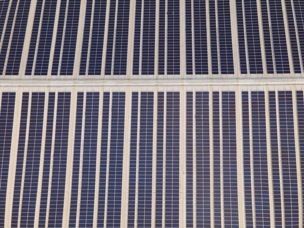 Aerial drone image of solar panels installed on a roof of a large industrial building or a warehouse. Industrial buildings.The renevable energy sustainable sources green power photovoltaic.