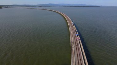 Pasak Chonlasit Barajı, Saraburi, Tayland 'dan geçen demiryolu manzarası çok güzel. Mavi gökyüzü güneşli ve körfezin suları sakin..