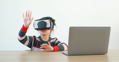 Evde gözlüklü VR giyen küçük kız sanal Global Internet bağlantısı metaevreninde oturuyor. Geleceğin beyaz elbiseli çocukları maç için VR kulaklık takıyor. kavramsal gelişmiş teknoloji. 