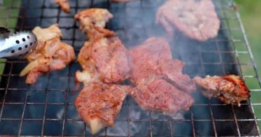 Baharatlı salamura sirke salamurası ve baharatlı et, yaz pikniği için açık havada odun ateşinde barbekü ızgarasında akşam yemeği için restoranın mutfağının önünde pişiriliyor.