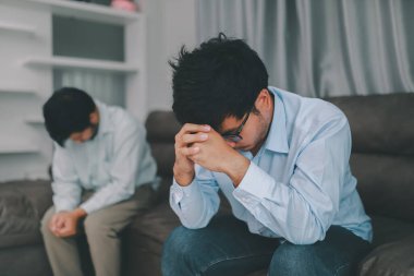 Homosexual male express sad or bad emotion from arguement or controversial problem. on sofas inside their homes, LGBTQ concept.