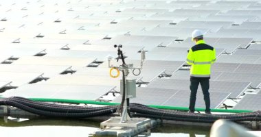 Portrait of professional man engineer working checking the panels at solar energy on buoy floating. Power plant with water, renewable energy source. Eco technology for electric power in industry.