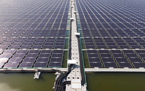 Aerial top view of solar panels or solar cells on buoy floating. Power plant with water, renewable energy source. Eco technology for electric power in industry. Alternative renewable energy.