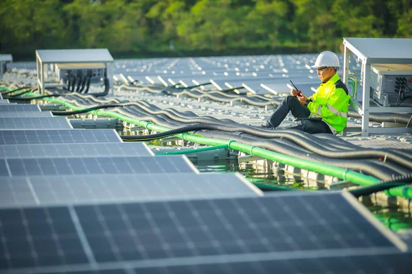 Portrait of professional man engineer working checking the panels at solar energy on buoy floating. Power plant with water, renewable energy source. Eco technology for electric power in industry.