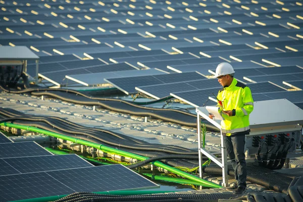 Portrait of professional man engineer working checking the panels at solar energy on buoy floating. Power plant with water, renewable energy source. Eco technology for electric power in industry.