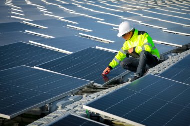 Portrait of professional man engineer working checking the panels at solar energy on buoy floating. Power plant with water, renewable energy source. Eco technology for electric power in industry.