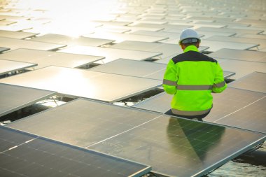Portrait of professional man engineer working checking the panels at solar energy on buoy floating. Power plant with water, renewable energy source. Eco technology for electric power in industry.