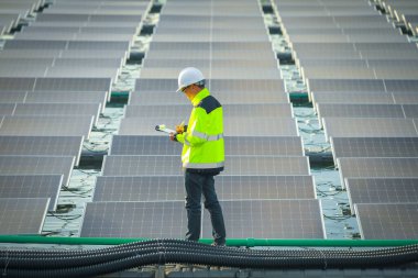 Portrait of professional man engineer working checking the panels at solar energy on buoy floating. Power plant with water, renewable energy source. Eco technology for electric power in industry.