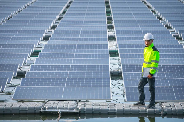 Portrait of professional man engineer working checking the panels at solar energy on buoy floating. Power plant with water, renewable energy source. Eco technology for electric power in industry.