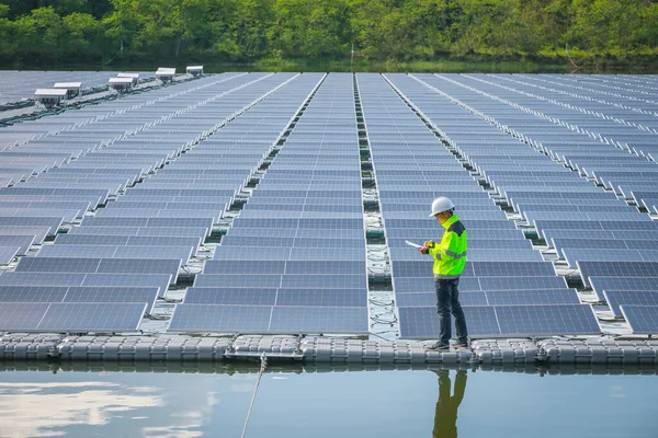 Portrait of professional man engineer working checking the panels at solar energy on buoy floating. Power plant with water, renewable energy source. Eco technology for electric power in industry.