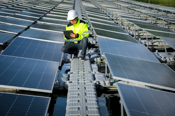 Portrait of professional man engineer working checking the panels at solar energy on buoy floating. Power plant with water, renewable energy source. Eco technology for electric power in industry.