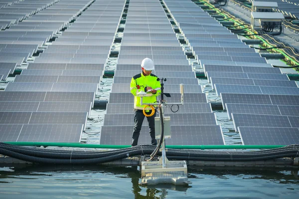 Portrait of professional man engineer working checking the panels at solar energy on buoy floating. Power plant with water, renewable energy source. Eco technology for electric power in industry.