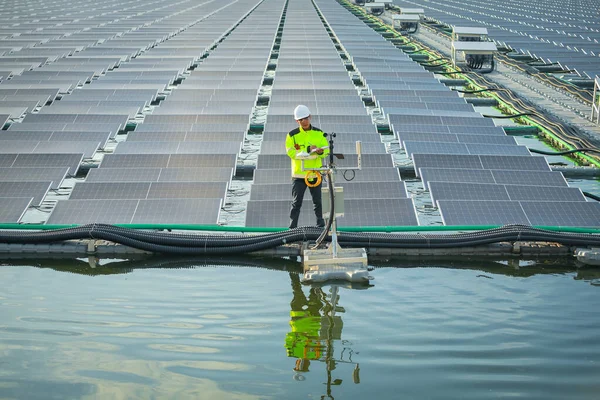 Portrait of professional man engineer working checking the panels at solar energy on buoy floating. Power plant with water, renewable energy source. Eco technology for electric power in industry.