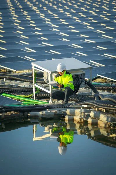 Portrait of professional man engineer working checking the panels at solar energy on buoy floating. Power plant with water, renewable energy source. Eco technology for electric power in industry.