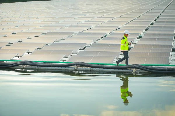 Portrait of professional man engineer working checking the panels at solar energy on buoy floating. Power plant with water, renewable energy source. Eco technology for electric power in industry.