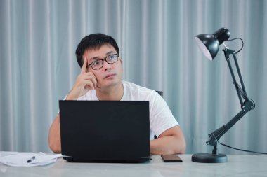 teknoloji, uzaktan iş ve yaşam tarzı konsepti - gözlüklü mutlu Asyalı adam evde veya online alışveriş, ev işi, serbest çalışma, çevrimiçi öğrenme, öğrenim.