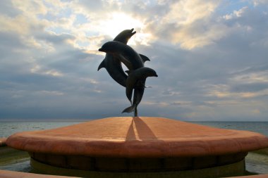 statue of couple jumping dolphins clipart