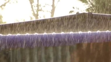 Yaz günbatımında çatıya yağmur yağıyor.