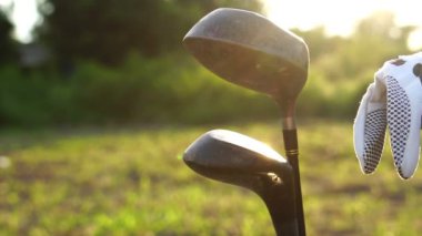 Golf sopalarının güzel manzarası ve gün batımında golf eldivenleri.
