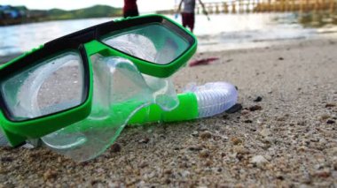 close-up footage of snorkeling mask and tube lying on beach