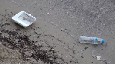 close-up footage of plastic pollution on sandy beach