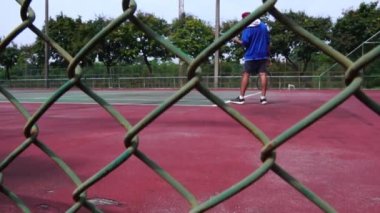 footage of man training to play tennis on outdoor court