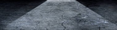 Shine of light on a dark concrete floor. Panoramic image