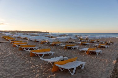 Kumsaldaki boş iskemleler. Kumsalda güneşli bir sabah