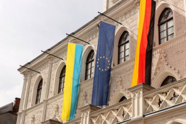 Tarihi bir binanın önünde Ukrayna, Almanya ve Avrupa Birliği bayrakları yan yana