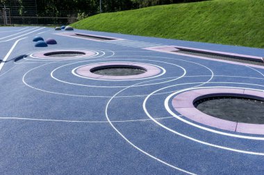 Dairesel trambolinler araziye gömülmüş. Modern yeni oyun alanı