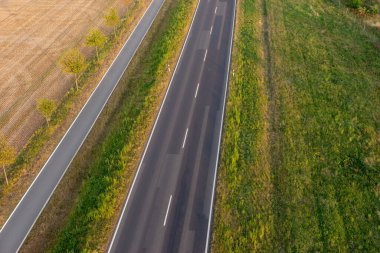 Yukarıdan tarlalar arasında boş asfalt yol ve bisiklet yolu