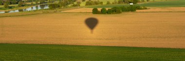 Sahada sıcak hava balonu gölgesi var. Panoramik resim