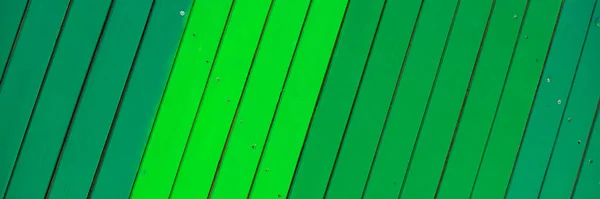 Panoramic image. Wooden green background. Wooden slats in different shades of green